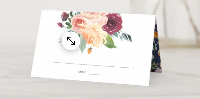 Fall Floral Wedding Place Card These autumn wedding place cards feature pretty watercolor flowers, including roses, dahlias, and buttercups. The front of the place card includes a fall floral bouquet above a place to write the guest's name and table number. On the back, a circle floral frame surrounds the couple's name and wedding date. The underside of the wedding place card features a navy blue background and pretty floral pattern